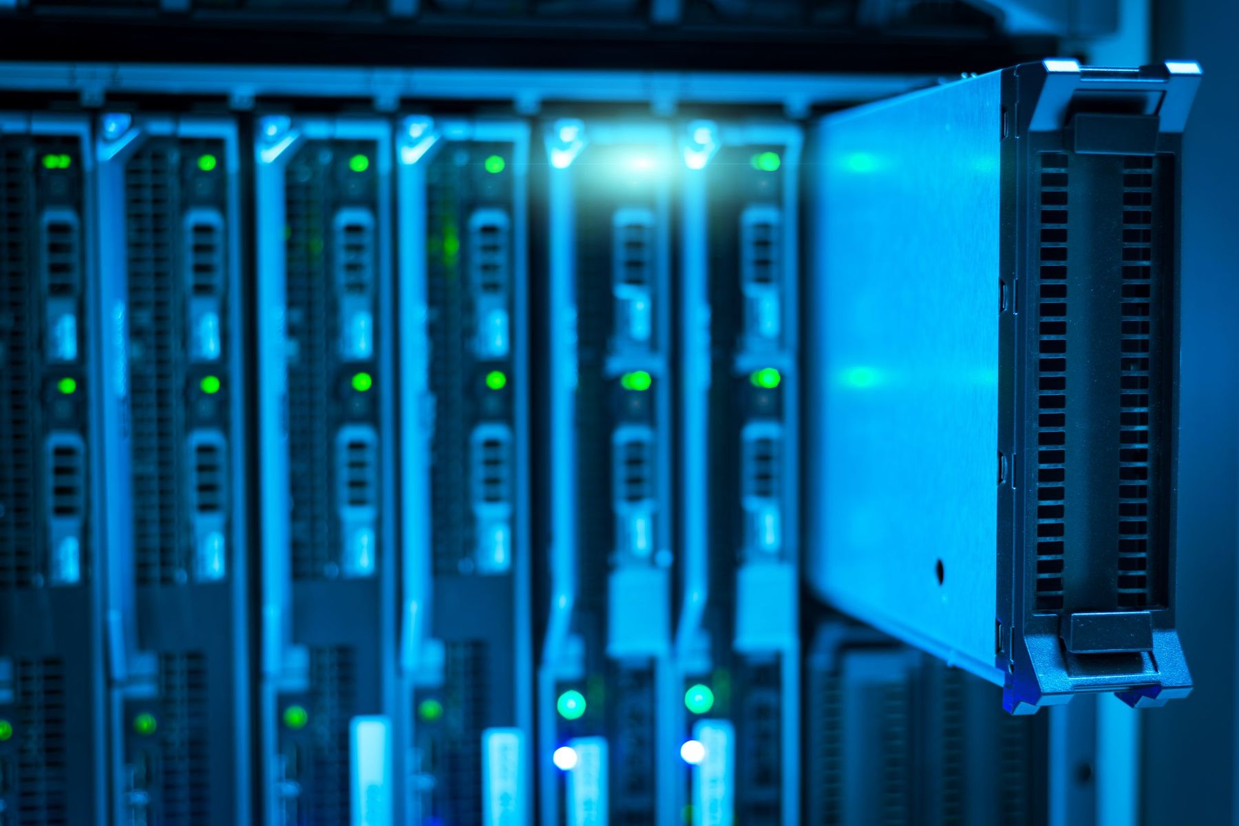 Blade servers with green status lights in a blue-lit data centre rack