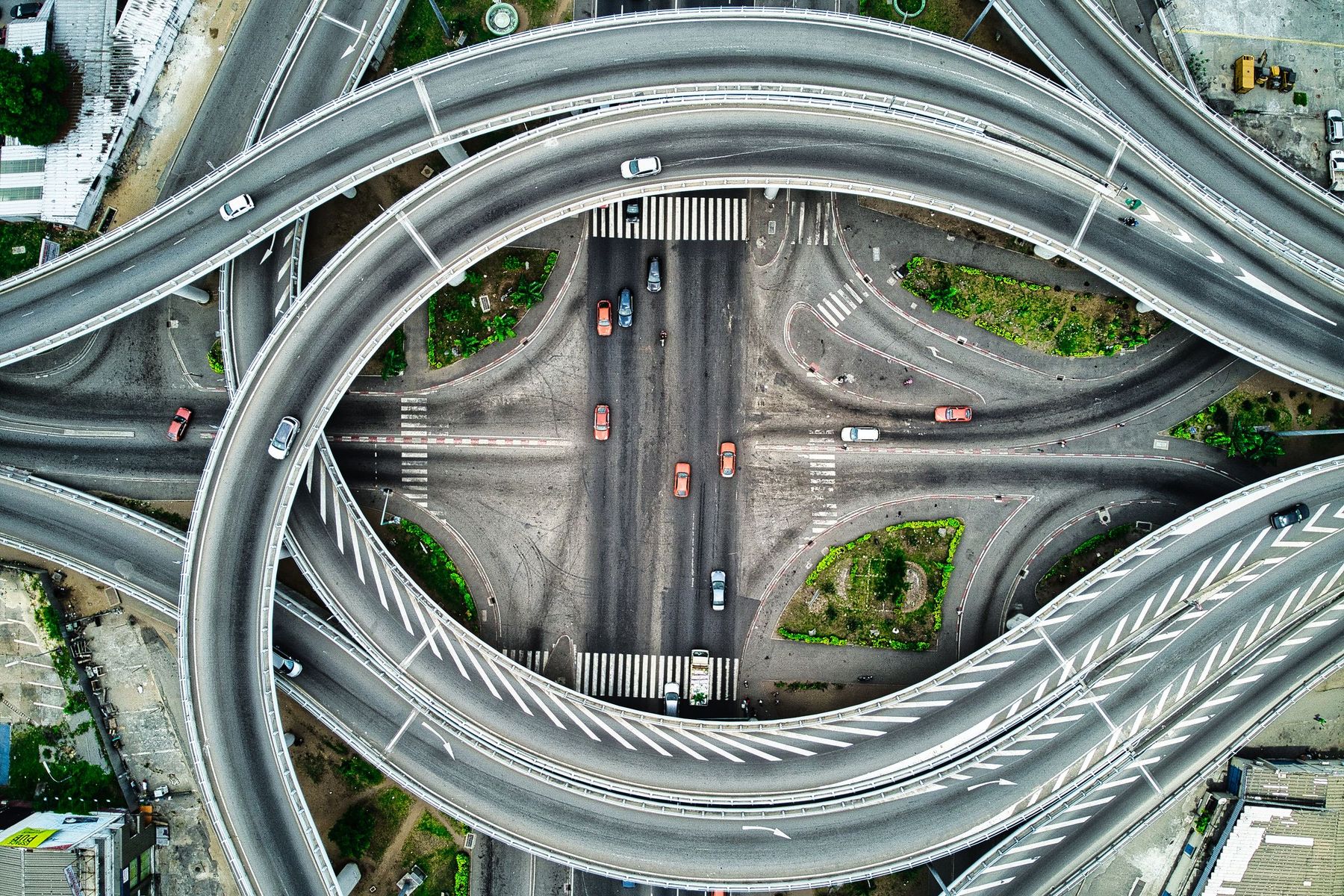 Top-down drone view of a multi-level highway interchange around a busy city intersection